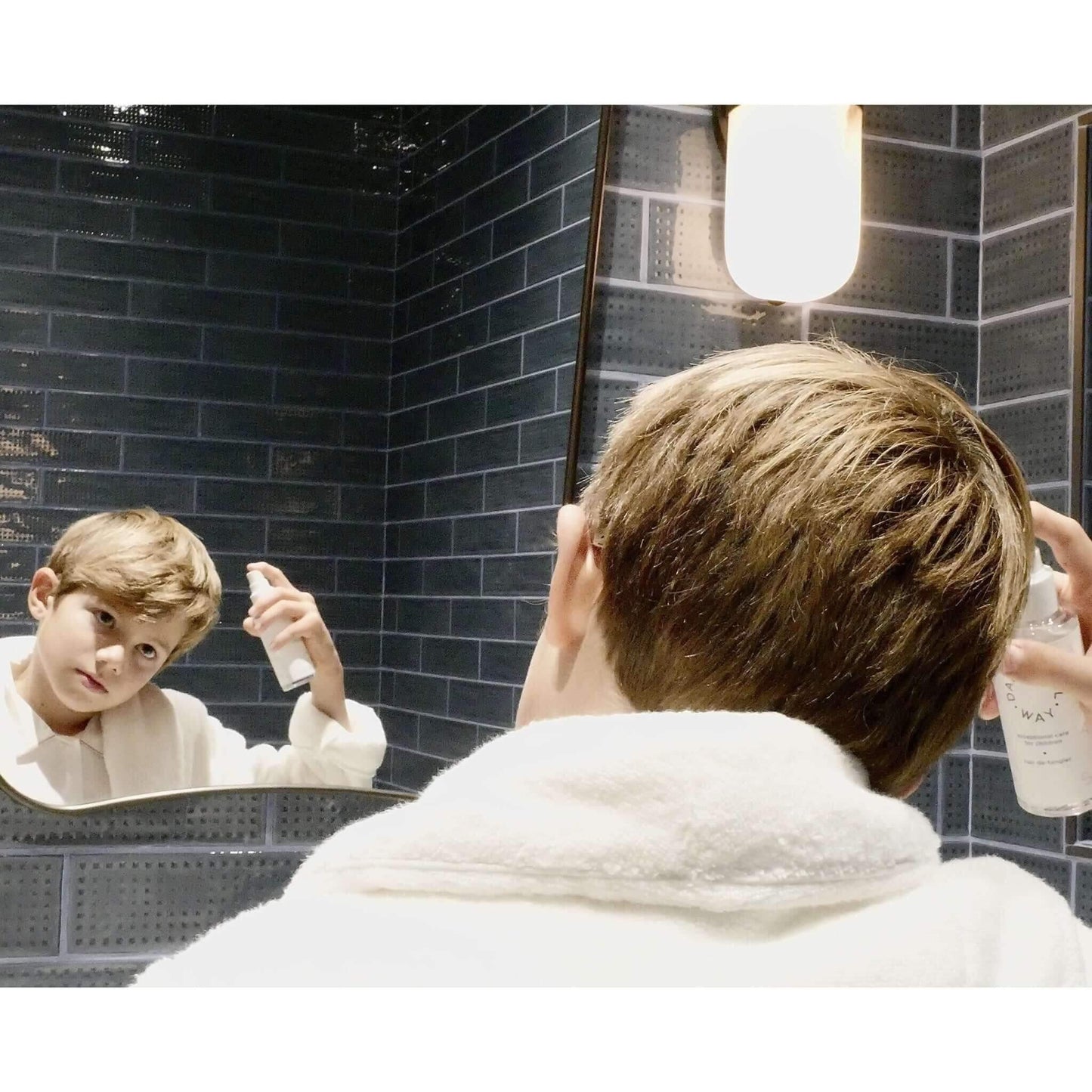 Young boy in white robe using silicone free hair de-tangler